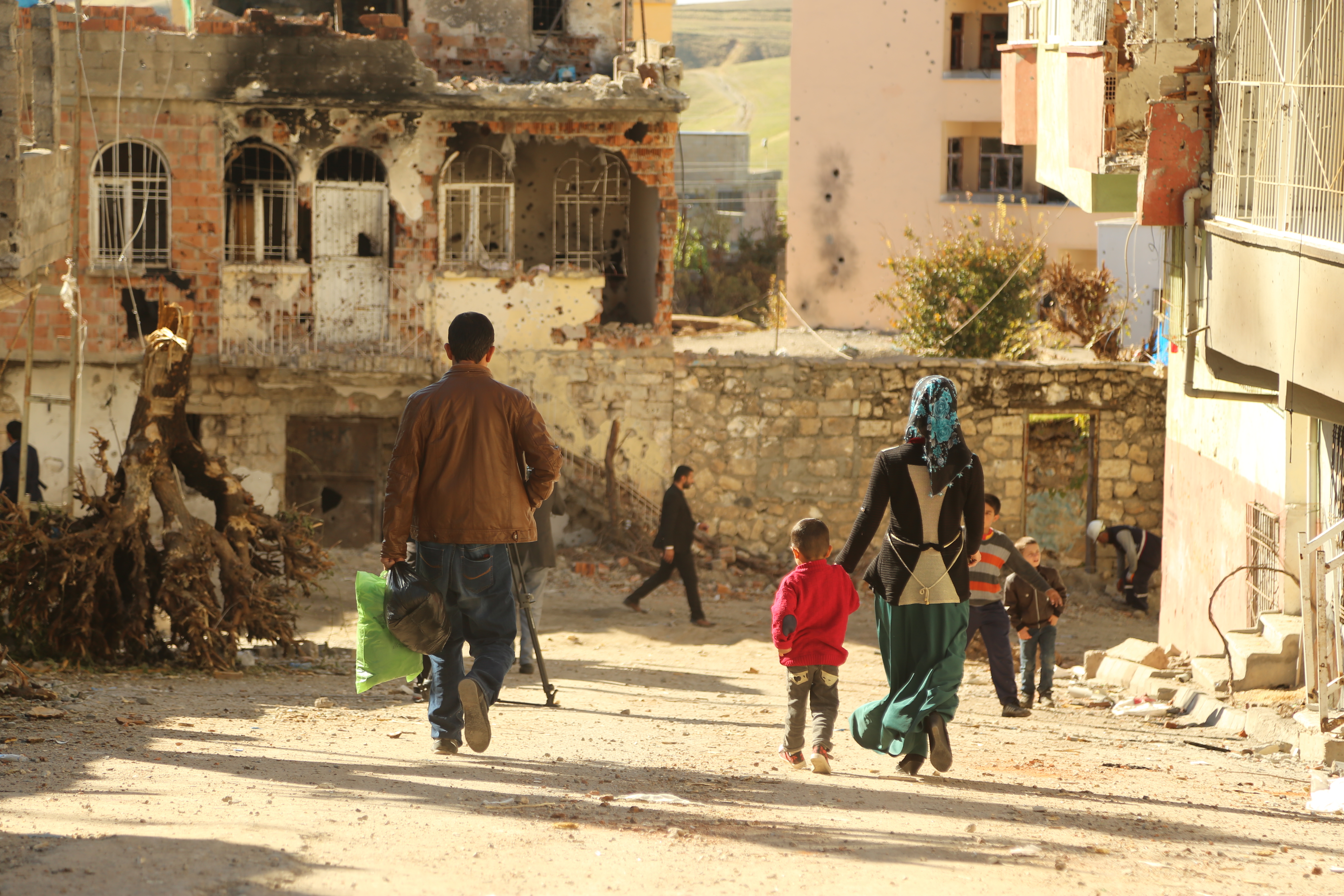 Residents of Farqîn walk amongst the destroyed houses. Picture taken by a friend from Farqîn.